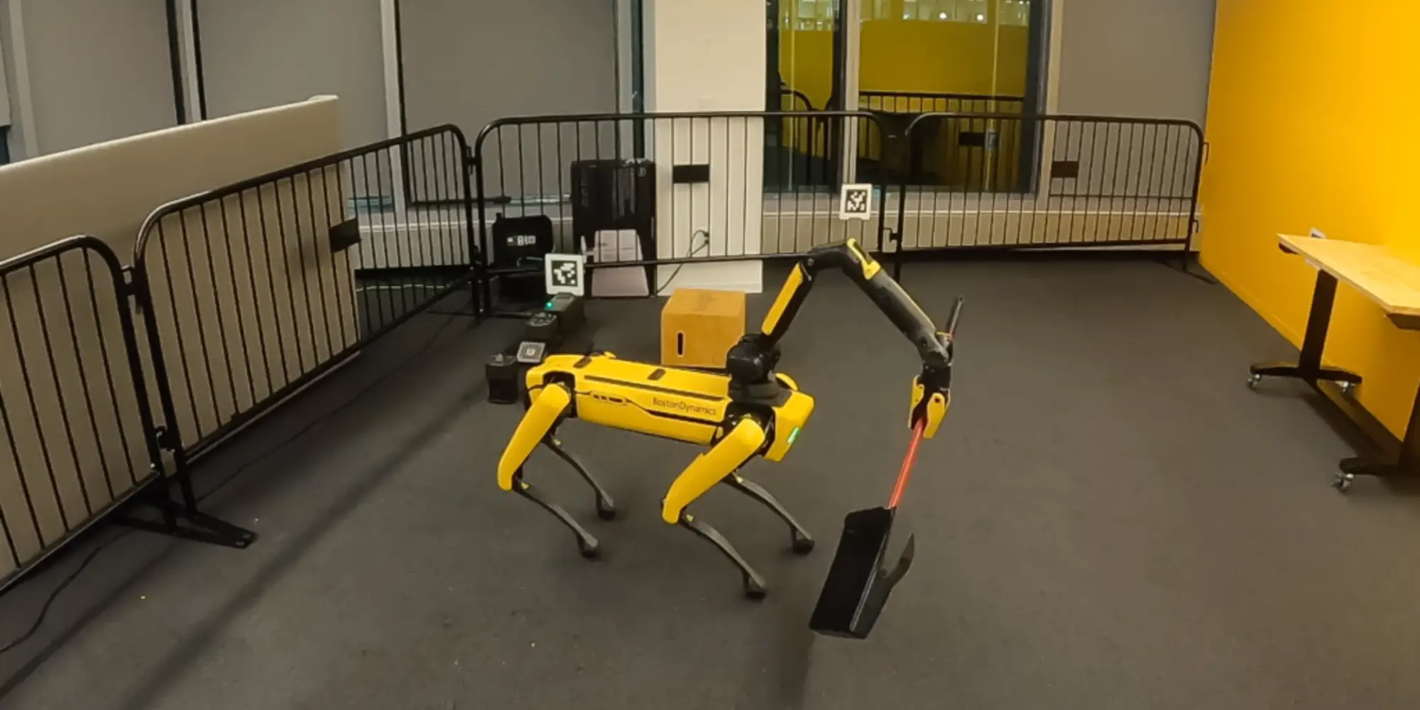 Four-legged robot holding a broom to sweep