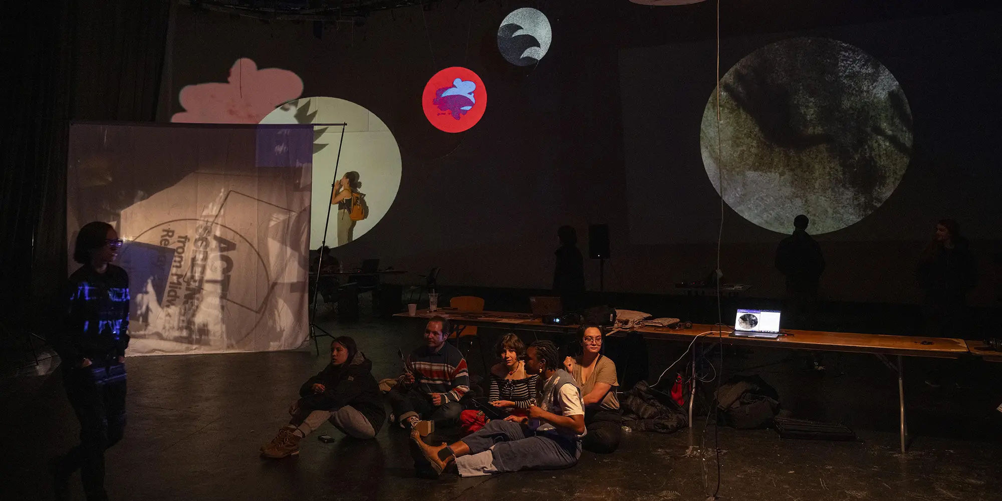 students seated on studio floor admiring projected world around them