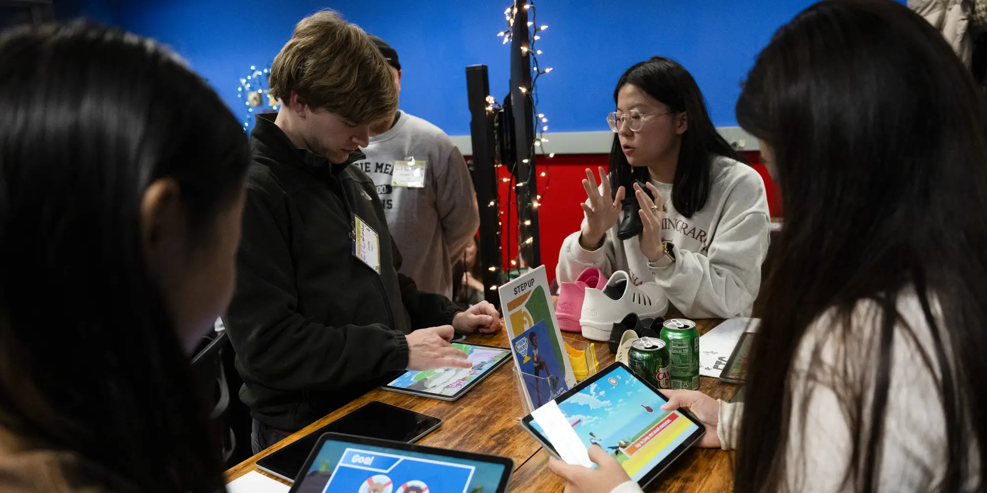 Students around a table working on tablets. 