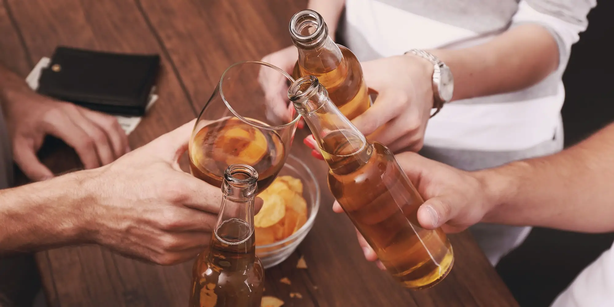 Multiple people holding alcoholic beverages together