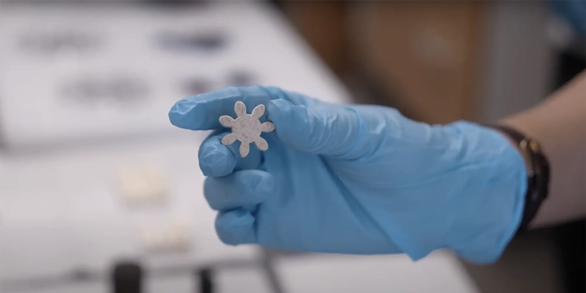 Gloved hand holding a star-shaped MXene.