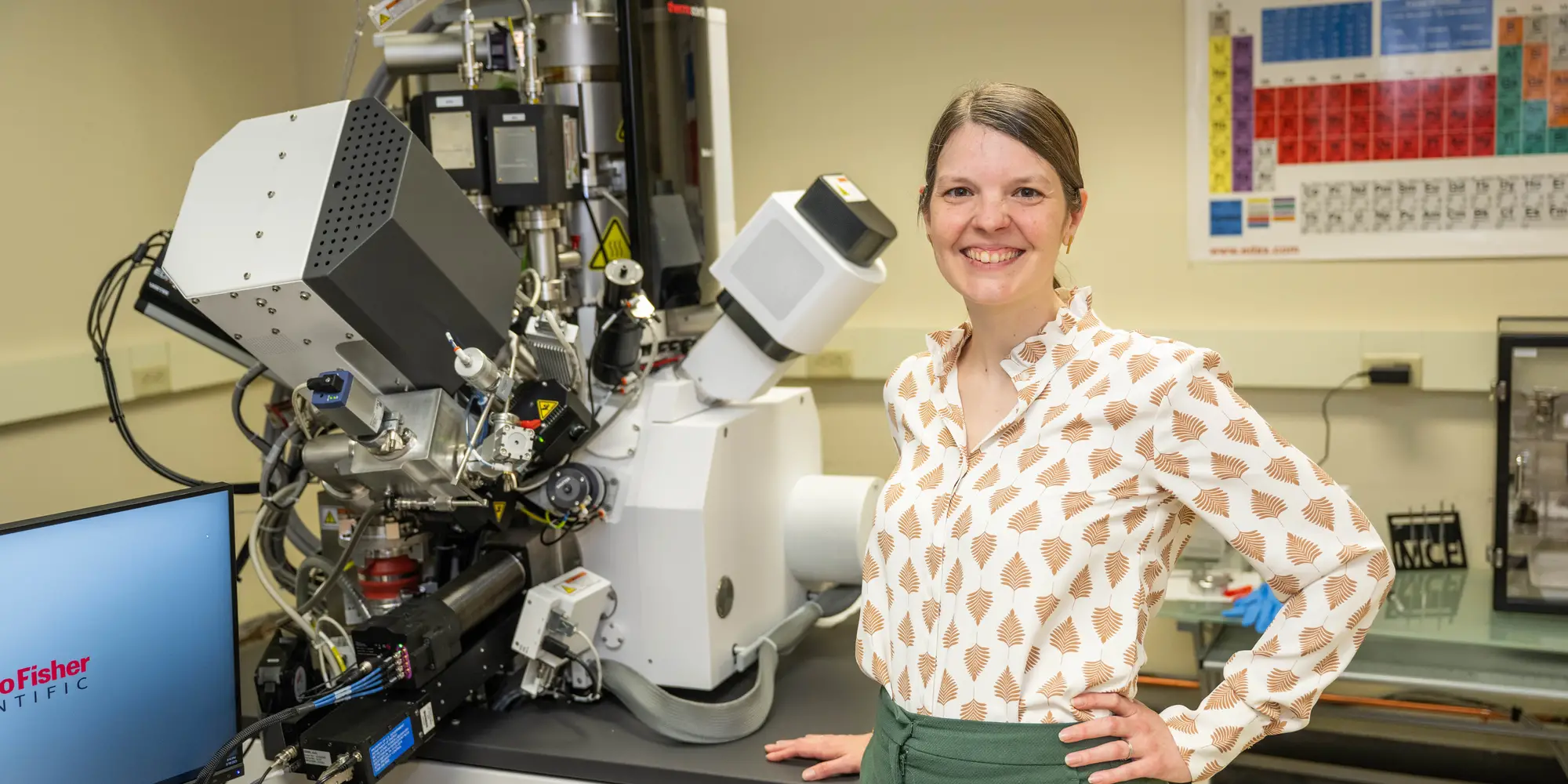 Amanda Krause next to a large microscope