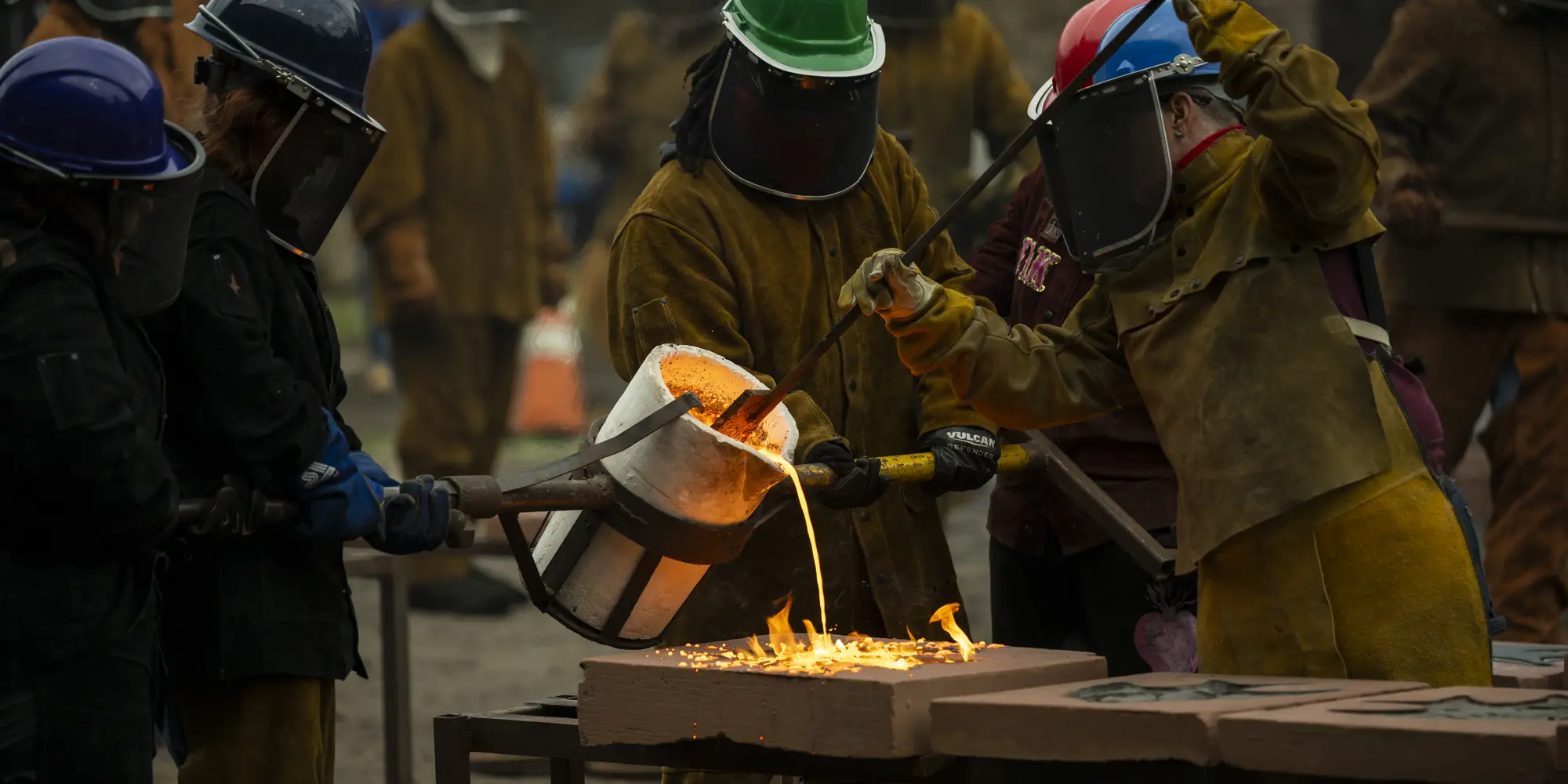 Students pour hot metal.