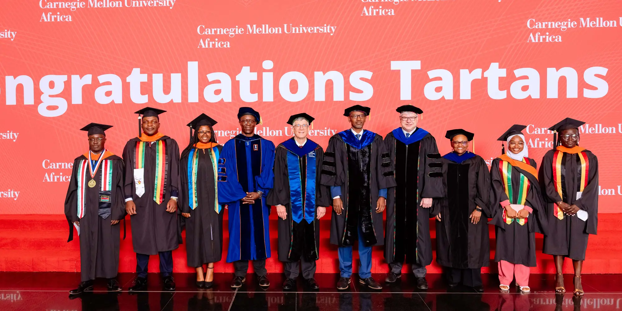 A group photo in front of a sign that reads "Congratulations Tartans."