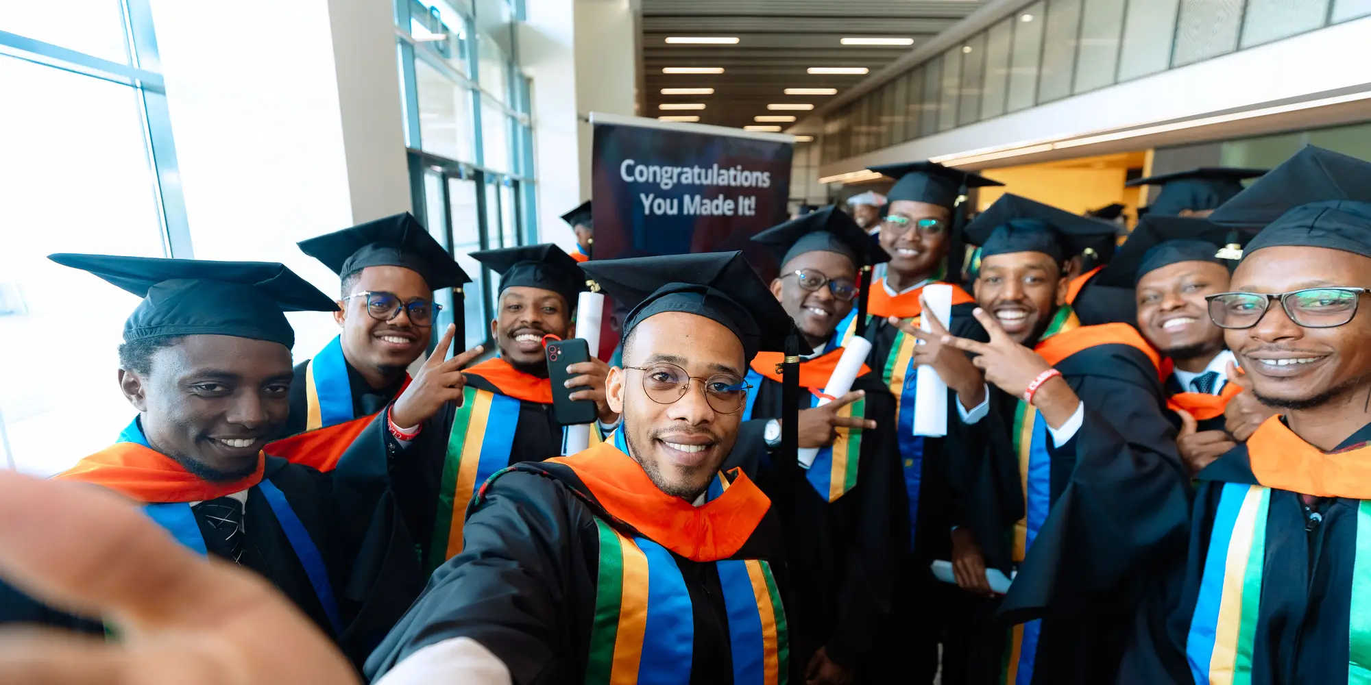 Graduates in caps and gowns pose for a photo at CMU-Africa.