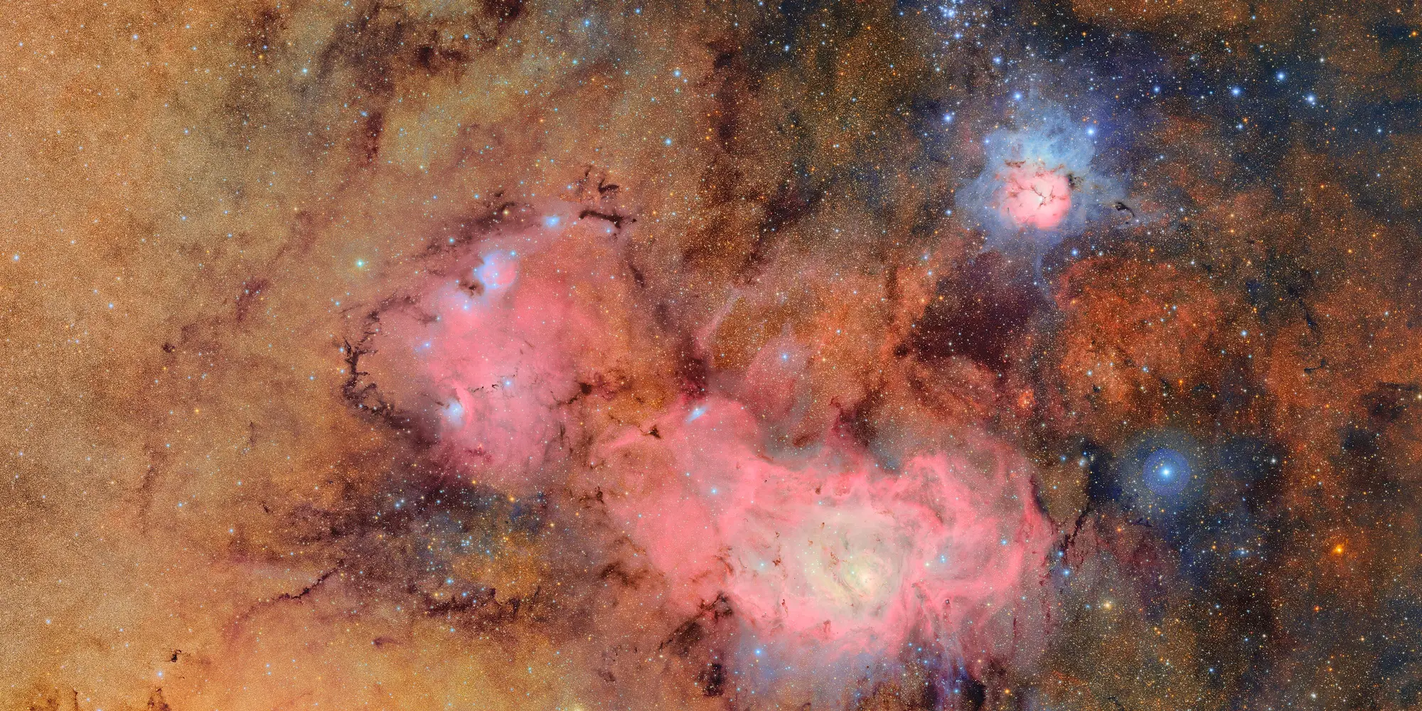 This image combines 678 separate images taken by NSF-DOE Vera C. Rubin Observatory in just over seven hours of observing time. Combining many images in this way clearly reveals otherwise faint or invisible details, such as the clouds of gas and dust that comprise the Trifid nebula (top right) and the Lagoon nebula, which are several thousand light-years away from Earth.