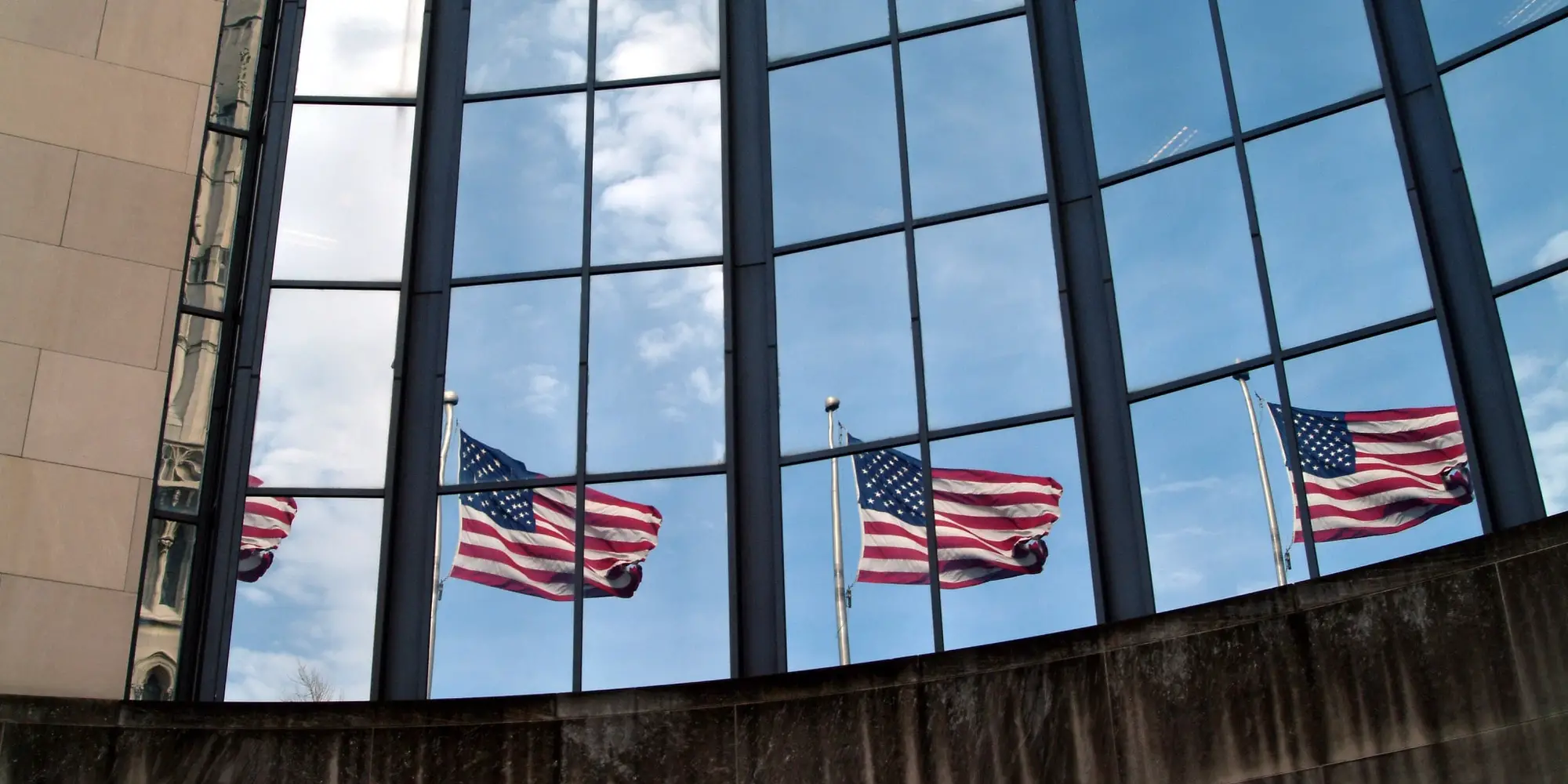 Exterior photo of the SEI building with four American flags