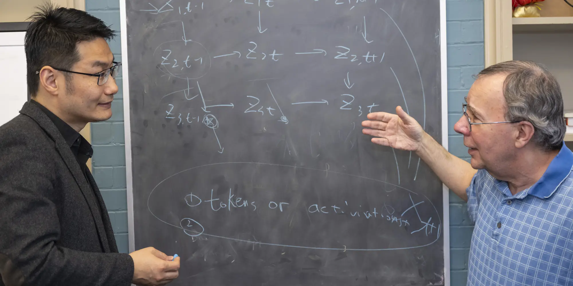 Kun Zhang and Peter Spirtes at a chalkboard.