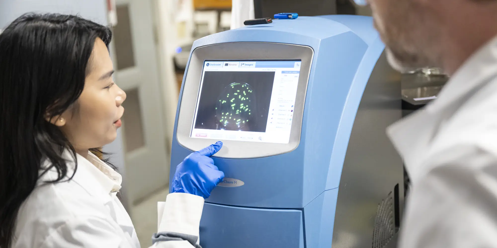 Scientists looking at machines in a lab.