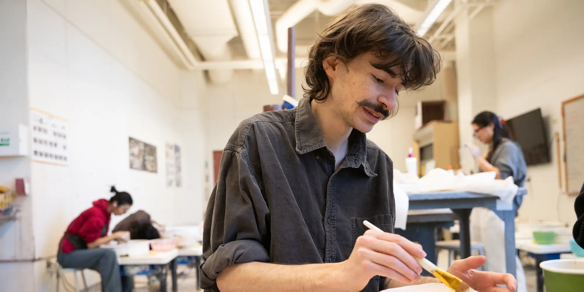 Students work on ‘empty bowls’ at the School of Art ceramic studio.