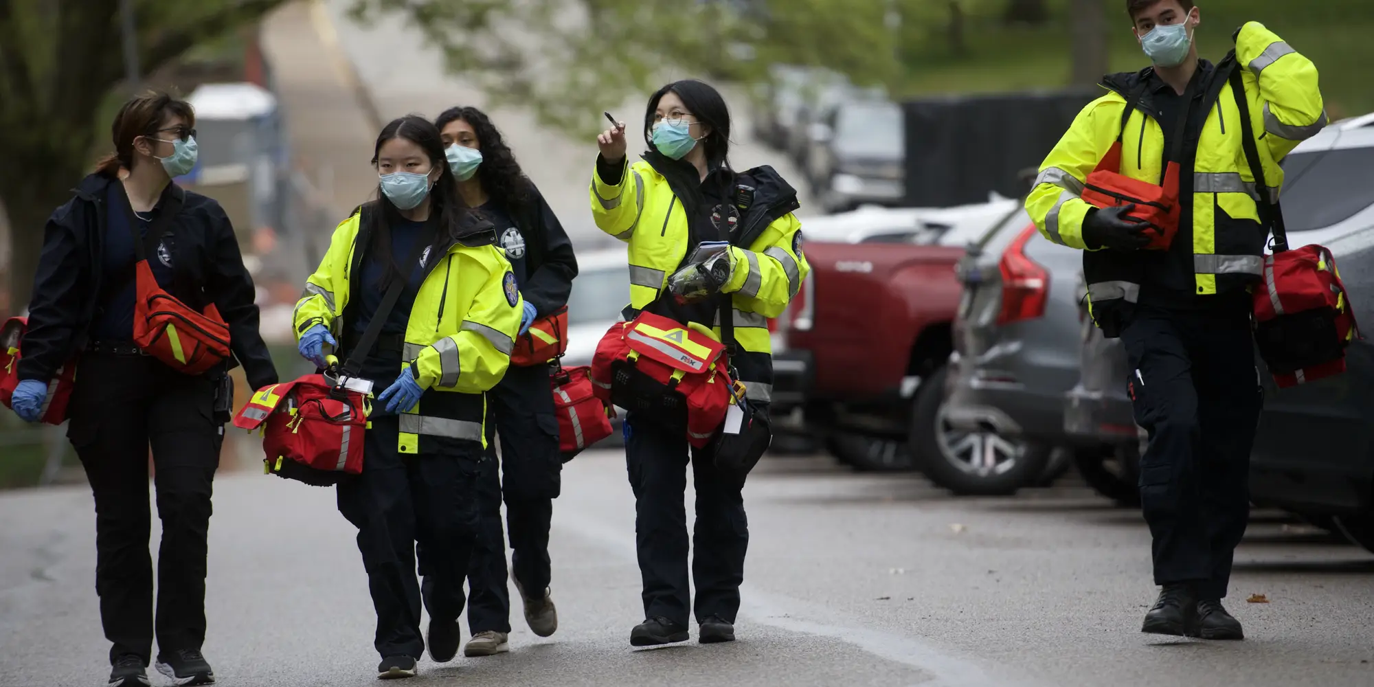 five emergency responders walk together wearing high visibility gear