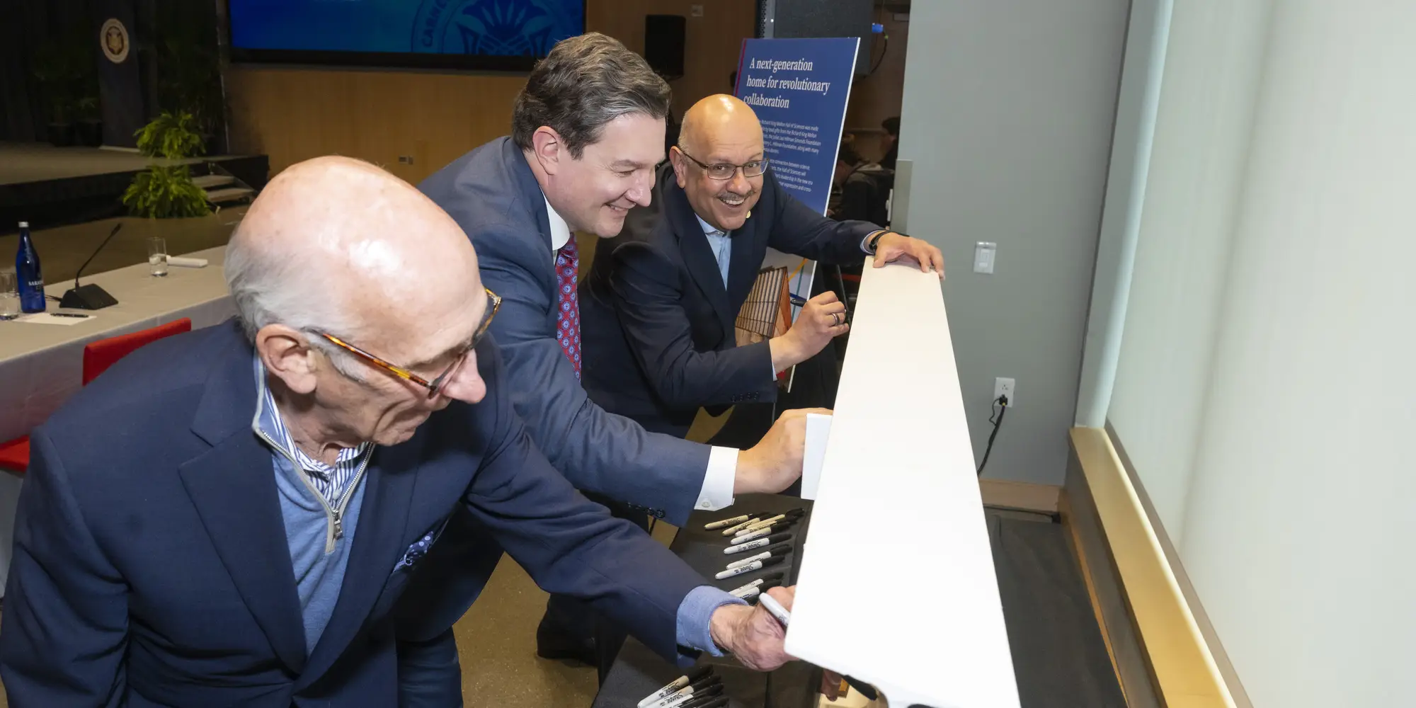 David Coulter, Sam Reiman, and Farnam Jahanian sign a beam for the Richard King Mellon Hall of Sciences