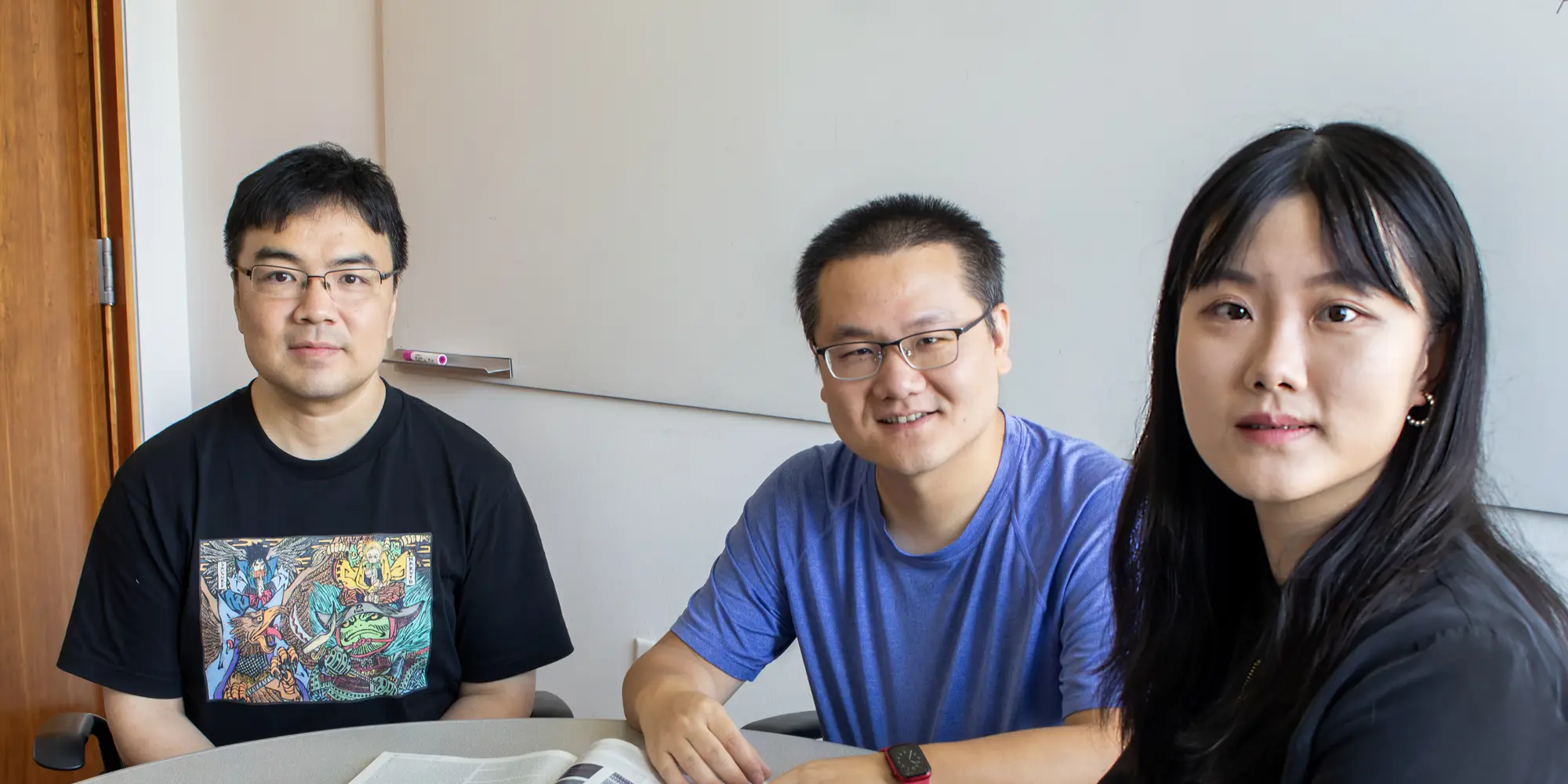 Three people sit in chairs for a portrait.