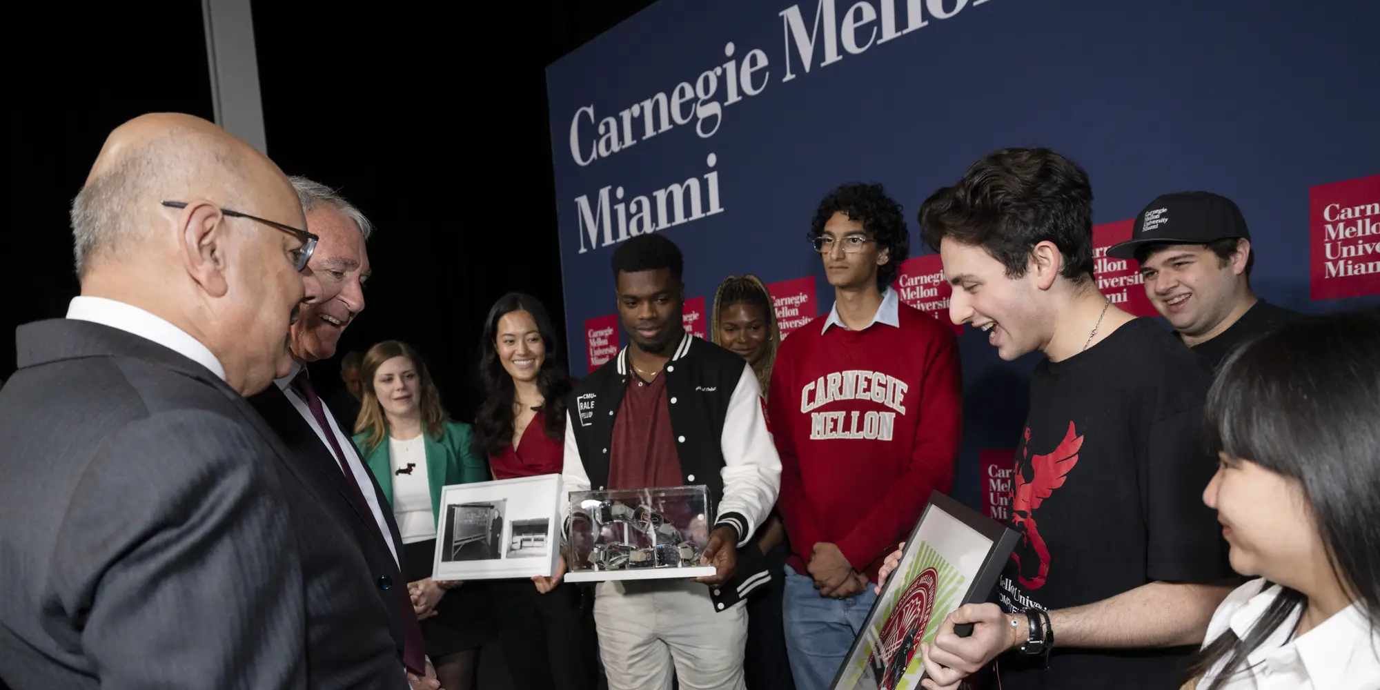 Farnam Jahanian and Ken Griffin greet CMU students in Miami. 