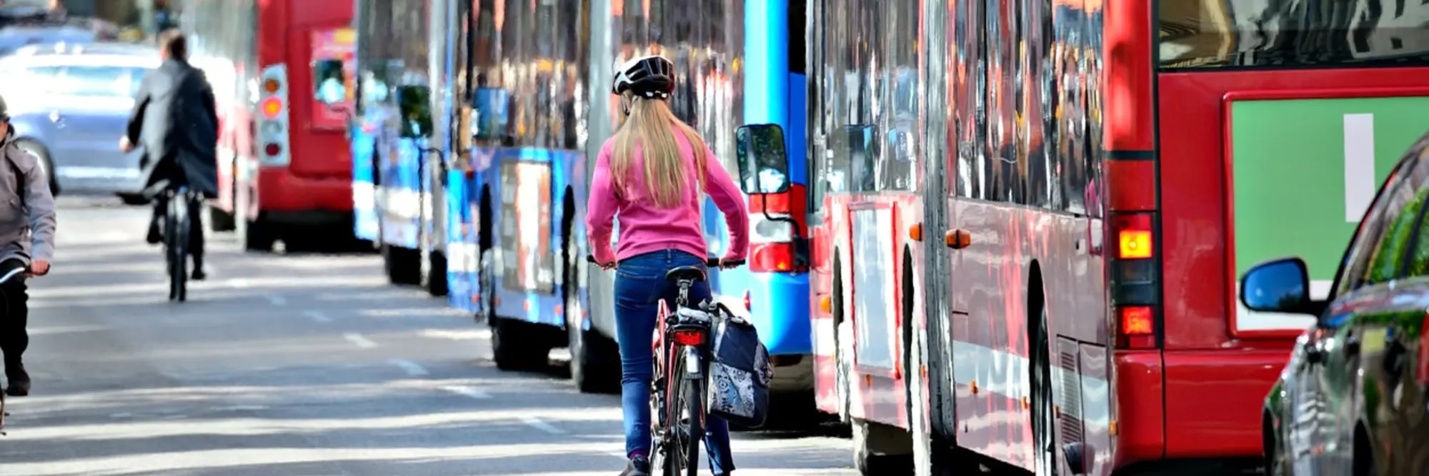 A bicyclist and a bus in traffic