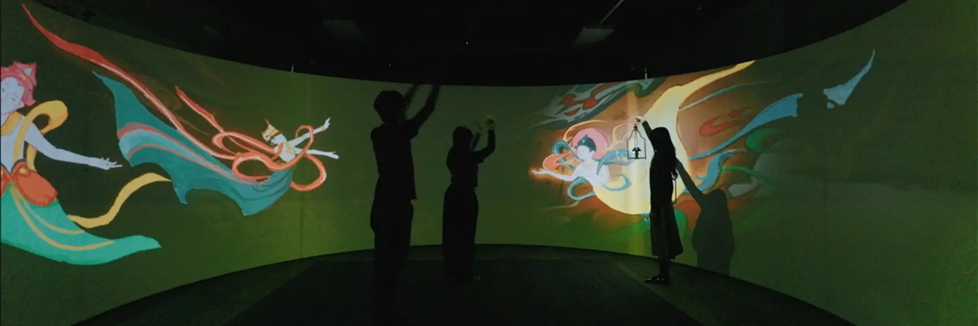 People in front of a large, colorful interactive screen. 