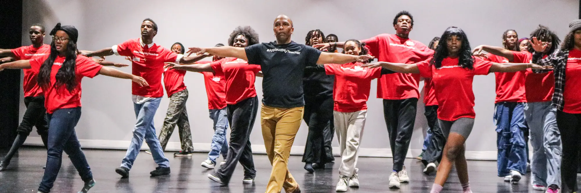 A line of dancers in red shirts. 