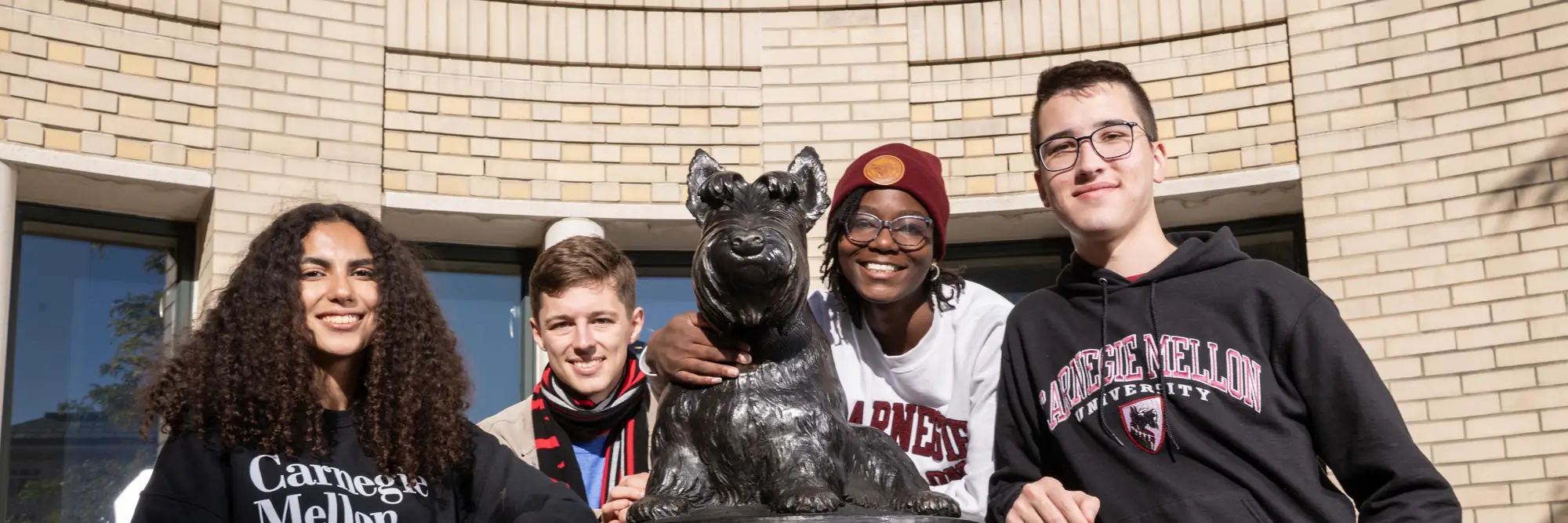 A group of students pose with the Scotty statue≥ 