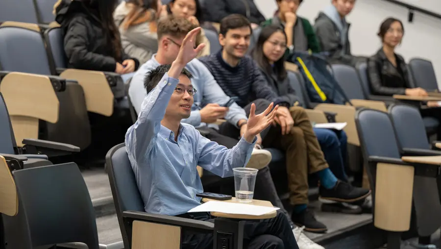 Po-Shen Loh seated in audience with his hand raised