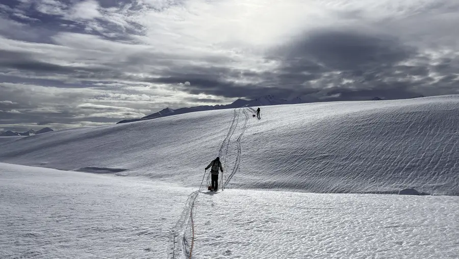 Two researchers trek across a glacier in Alaska.