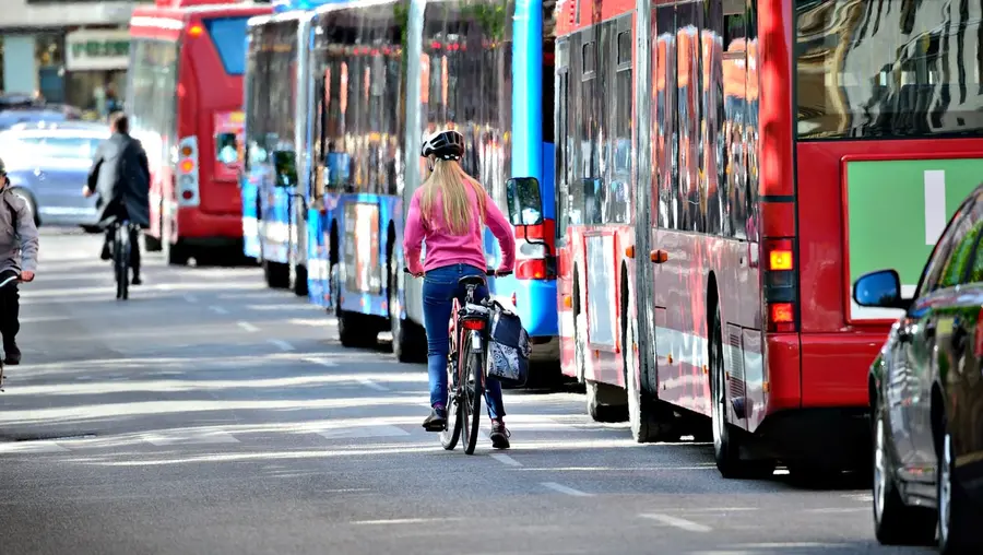 A bicyclist and a bus in traffic