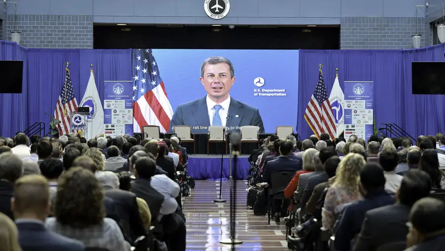 U.S. Secretary of Transportation Pete Buttigieg appears on screen at transportation summit