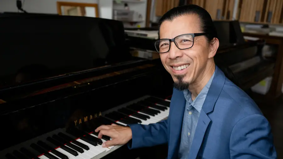 Frederic Chiu seated at Yamaha piano smiling