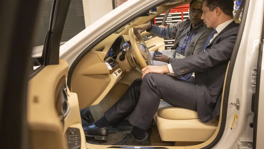 Nishad Sahu, Ph.D. candidate in Electrical and Computer Engineering, explains the features of an autonomous Cadillac CT6 to U.S. Secretary of Transportation Pete Buttigieg