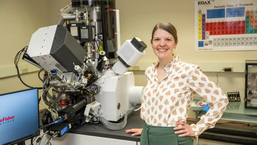Amanda Krause next to a large microscope