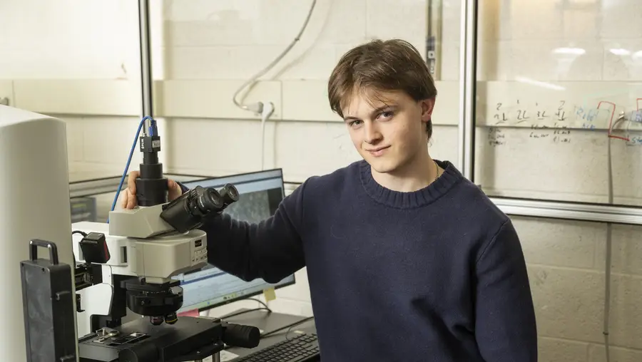 Patrick Kaczmarek in a lab with a microscope. 