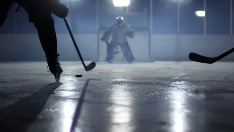 A hockey goalie is shown ready to defend the goal.