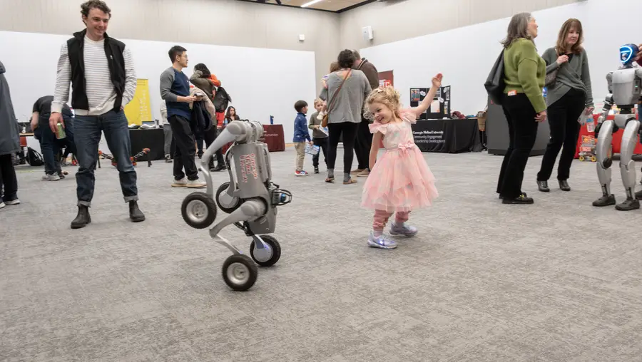 A child plays with a robot at CMU's RIC community event. 