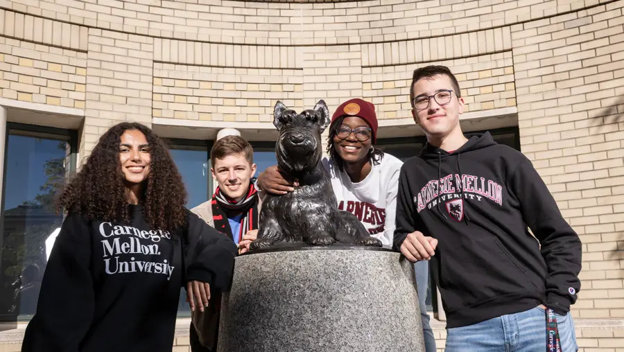 A group of students pose with the Scotty statue≥ 