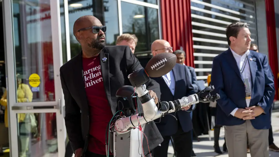 ETC director Derek Ham shows off a robot that can throw a football. 