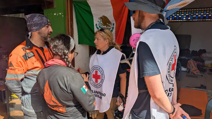 four people wearing rescue gear stand facing one another