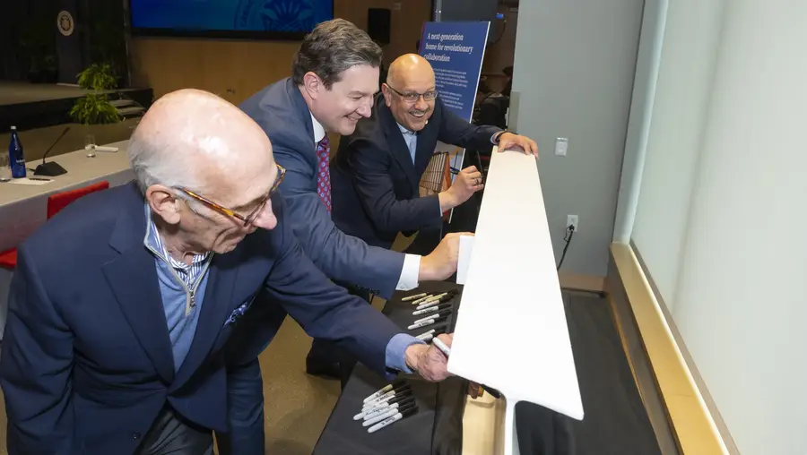 David Coulter, Sam Reiman, and Farnam Jahanian sign a beam for the Richard King Mellon Hall of Sciences