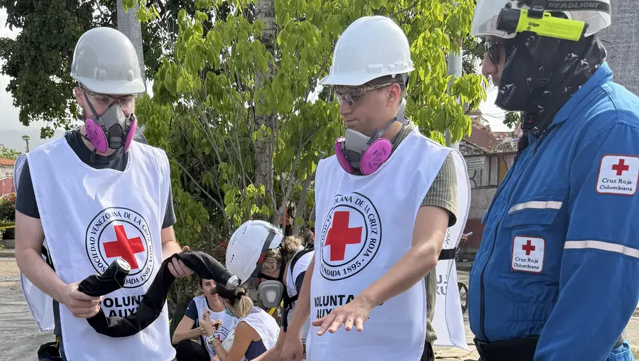 Darwin Mick and Nico Zevallos-Roberts, members of the Biorobotics Lab at Carnegie Mellon University’s Robotics Institute, show the snake robot to the Colombian Red Cross as they assist with search and rescue efforts following earthquakes in Venezuela.
