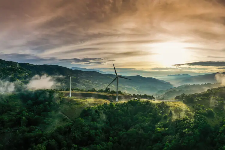 green landscape showing wind turbine with sky in background