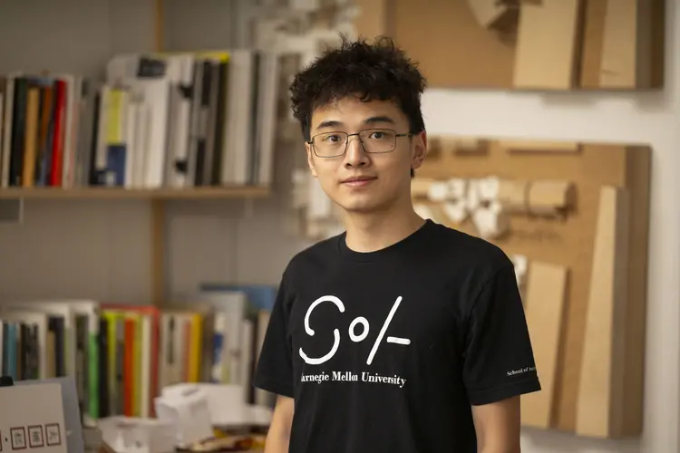 Andy Jiang wearing black SoA t-shirt inside classroom