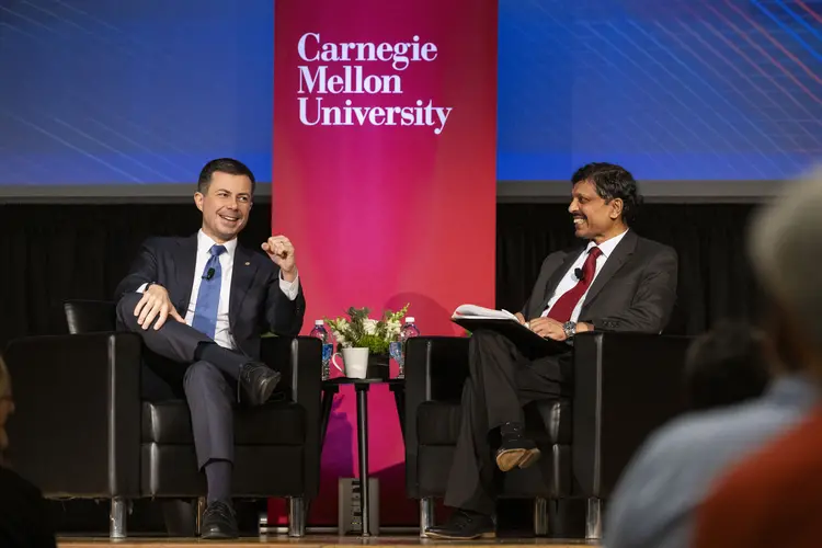 Pete Buttigieg and Raj Rajkumar talk during a Q&A.