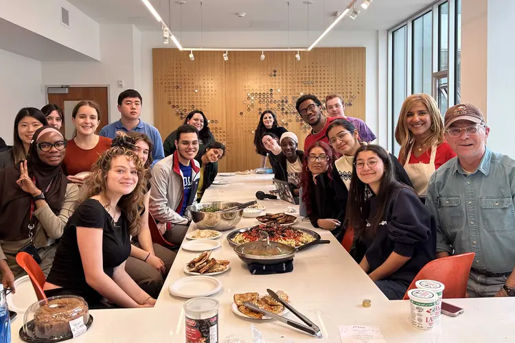 A group photo taken over cultural food prepared for Friendsgiving