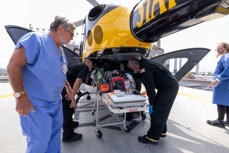 People load things into a helicopter.