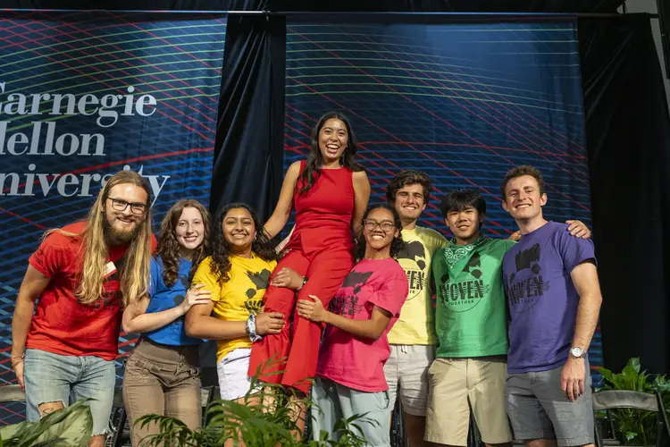 Orientation counselors pose for a group photo, lifting up fellow head counselor and event emcee Elizabeth Zapanta.