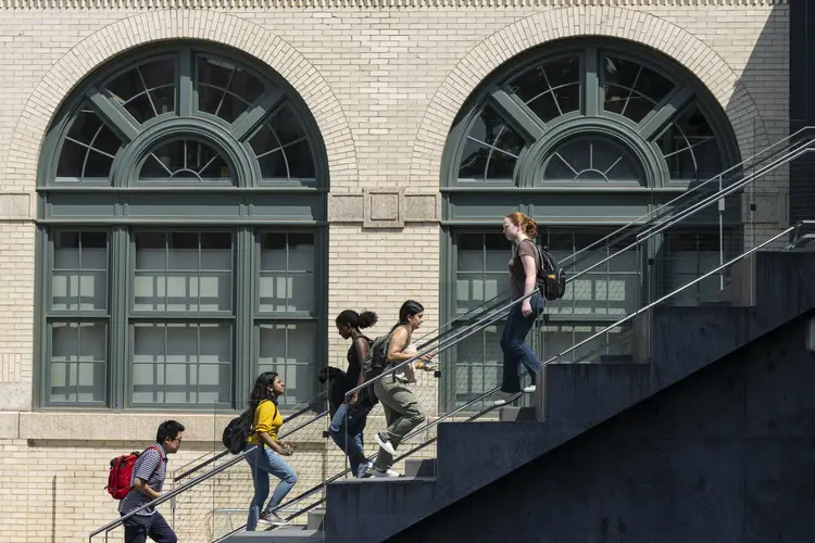 Students walk past a large set of windows on CMU campus.