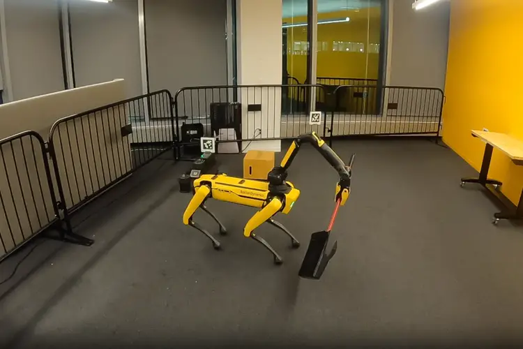 Four-legged robot holding a broom to sweep