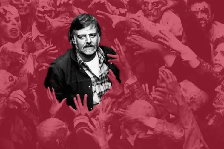 George Romero surrounded by zombies.