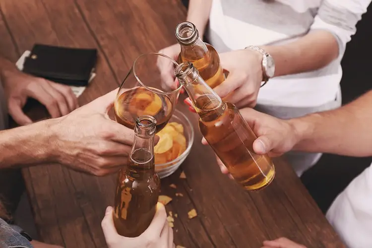 Multiple people holding alcoholic beverages together