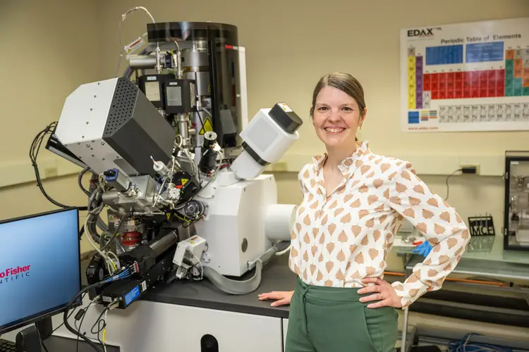 Amanda Krause next to a large microscope
