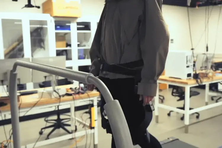 College of Engineering student Manaen Hu walking with a prototype exoskeleton on a treadmill.