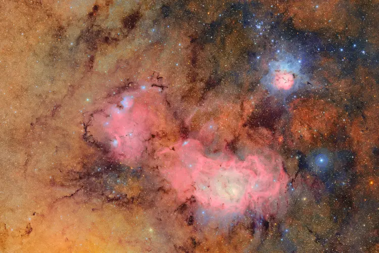 This image combines 678 separate images taken by NSF-DOE Vera C. Rubin Observatory in just over seven hours of observing time. Combining many images in this way clearly reveals otherwise faint or invisible details, such as the clouds of gas and dust that comprise the Trifid nebula (top right) and the Lagoon nebula, which are several thousand light-years away from Earth.